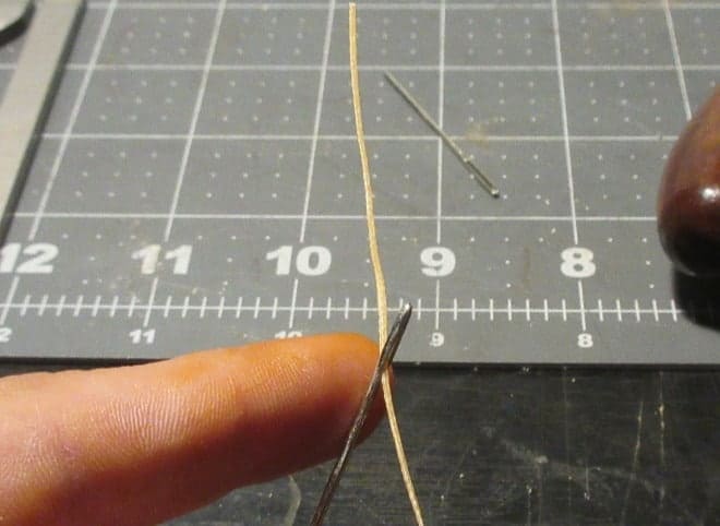 Threading a needle for stitching leather