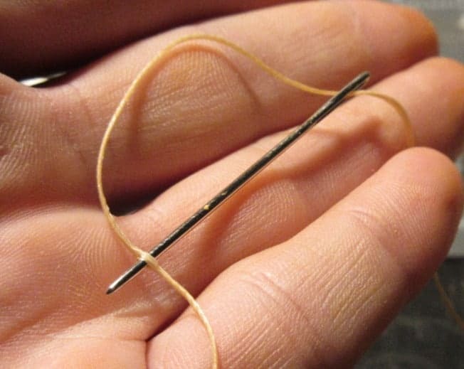 Threading a needle for stitching leather