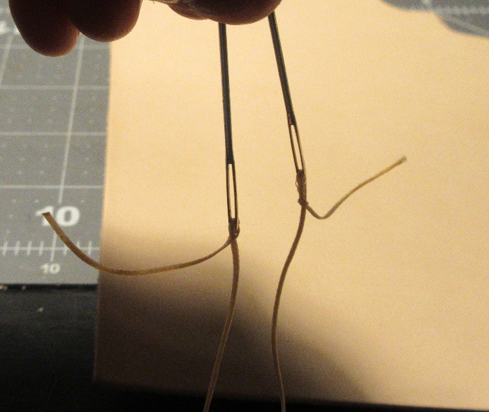 Threading a needle for stitching leather